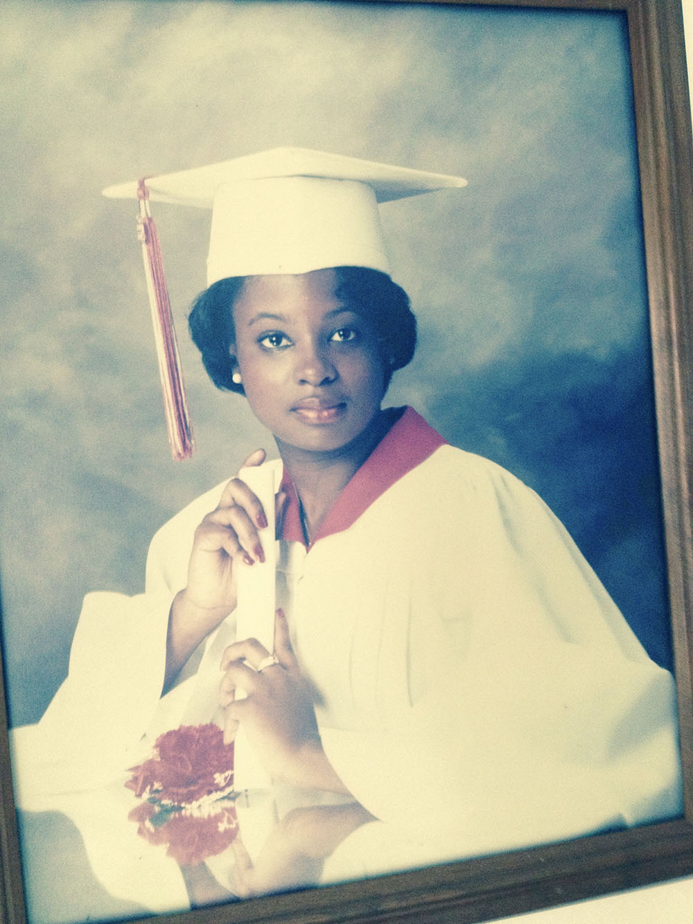 A young woman wearing a graduation cap and gown.