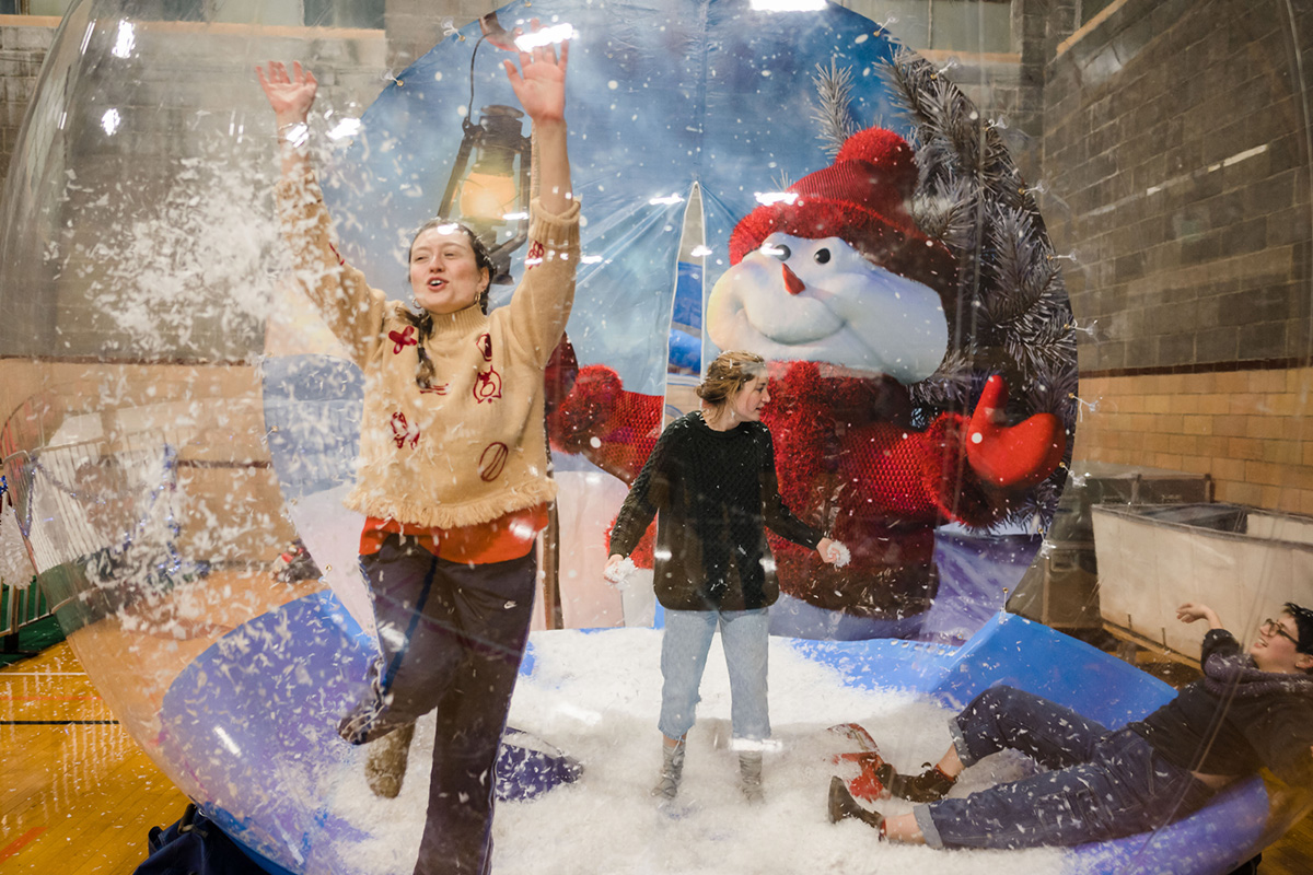 Several students play in giant snow globe.